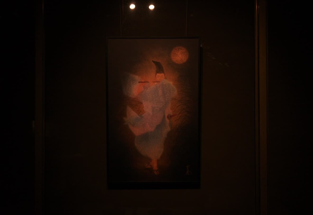 個展会場に展示された、月夜に笛を吹く人物の絵