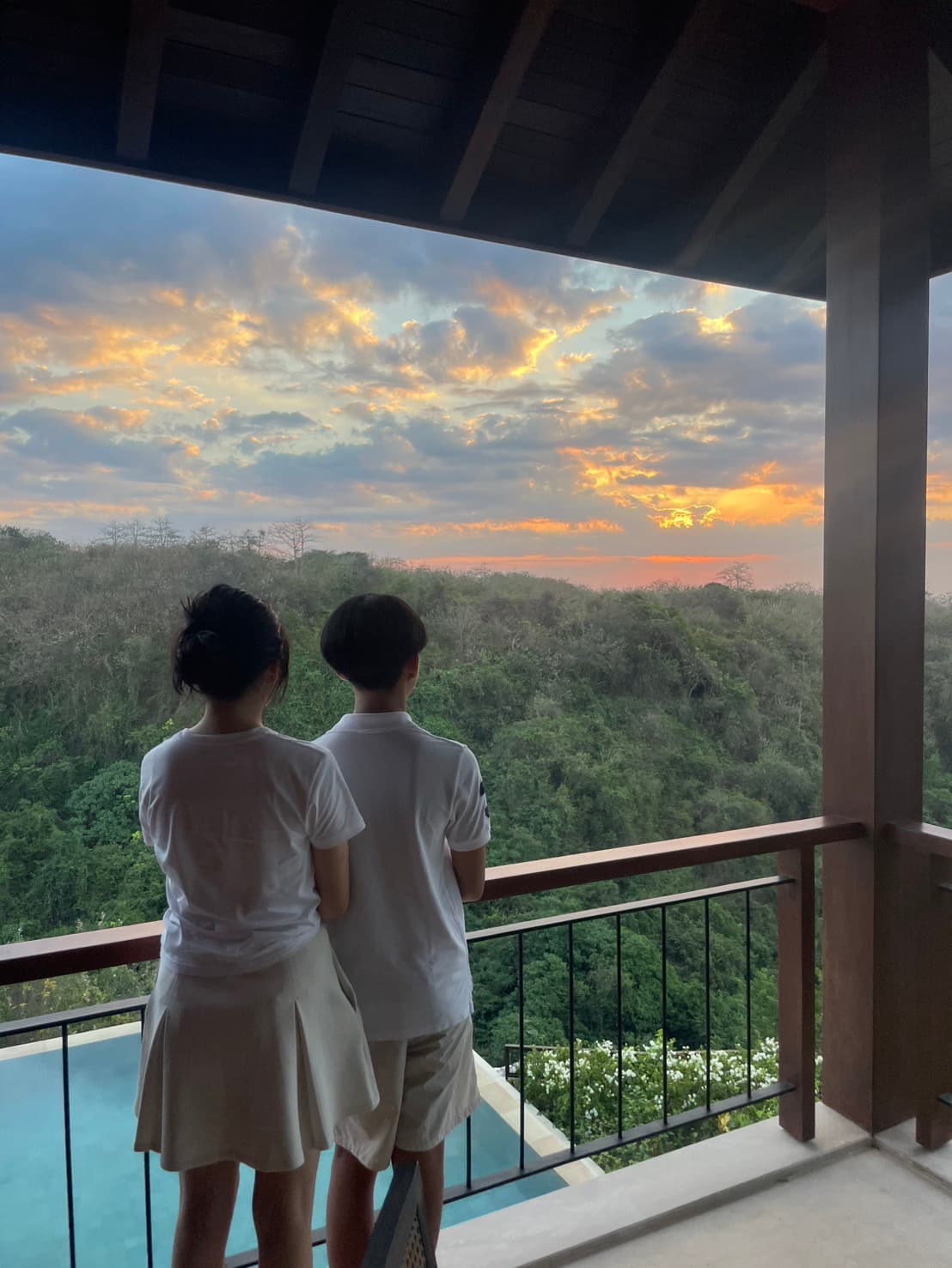 夕暮れのバルコニーに立つ家族