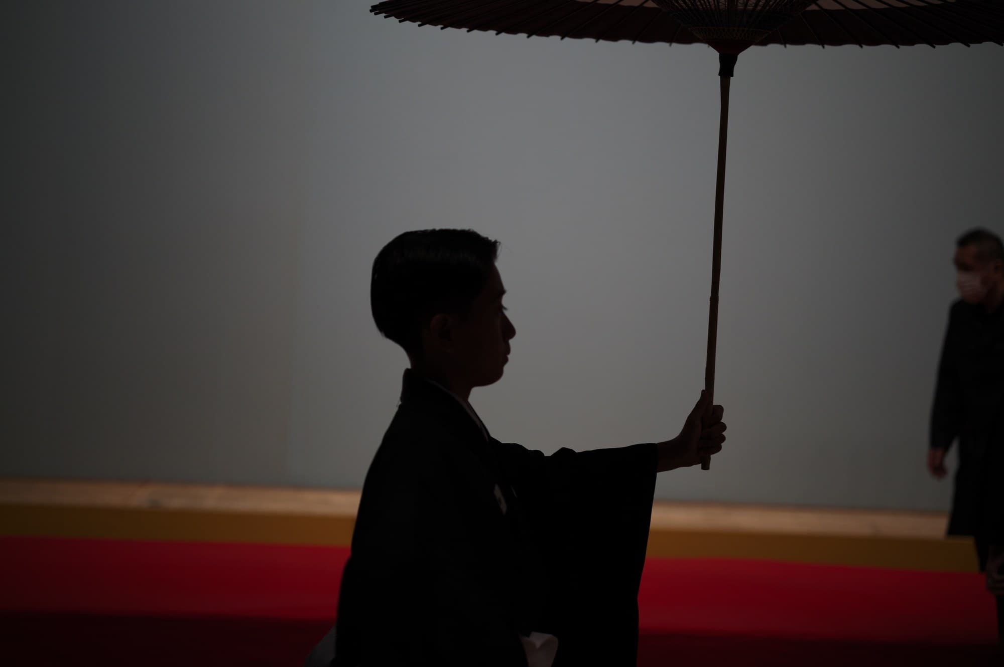 番傘を掲げる人物の横顔のシルエット
